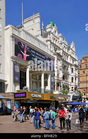 Geschäftiger Bürgersteig mit Leuten vor dem Empire Cinema und Casino Gebäude am blauen Himmel sonniger Frühlingstag in Leicester Square West End London England Großbritannien Stockfoto