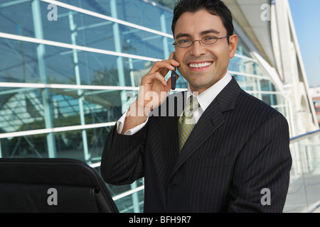 Geschäftsmann mit Handy vor Bürogebäude, Porträt Stockfoto