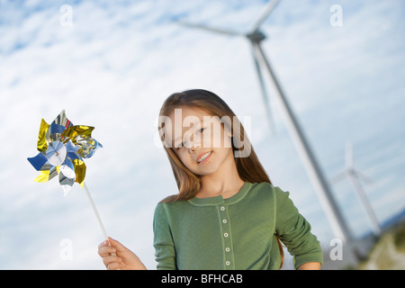 Mädchen (5-6) Holding Spielzeug Windmühle im Windpark Porträt Stockfoto