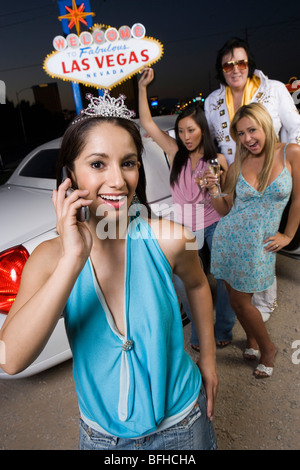 Porträt der jungen Frau, zwei Frauen mit Elvis-Imitator im Hintergrund, Las Vegas, Nevada, USA Stockfoto