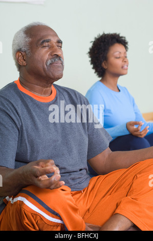 Senior woman meditieren im Yoga-Kurs Stockfoto