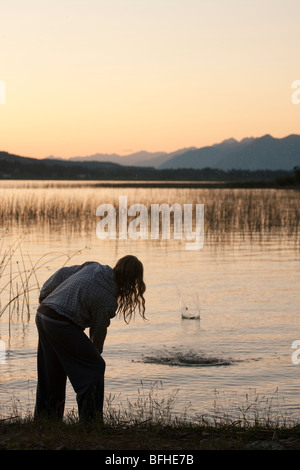 Ein Weibchen überspringt einige Felsen auf Columbia See bei Sonnenuntergang Stockfoto