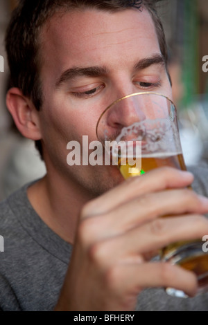 junger Mann, ein Bier trinken Stockfoto