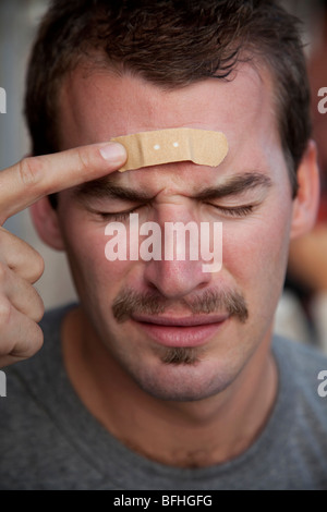 Junger Mann mit einem Pflaster auf der Stirn Stockfoto