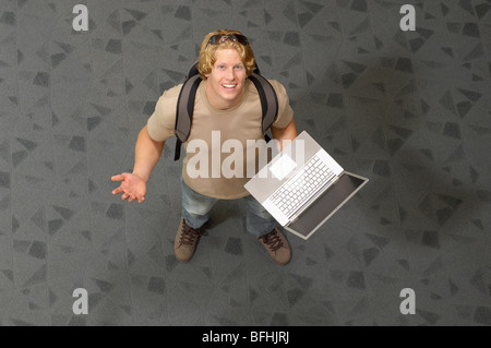 Männlichen Studenten Laptop, drinnen halten, portrait Stockfoto