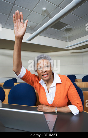 Reife Studentin Erhöhung Hand im Hörsaal Stockfoto