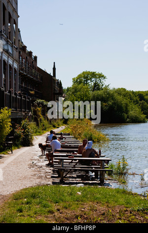 Menschen sitzen vor der White Hart Pub am Mortlake High Street im Sommer. Die Themse Runden zu ihren Füßen. Stockfoto