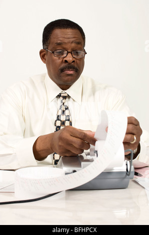 Buchhalter, lesen eine hinzufügen von Maschine-Band Stockfoto