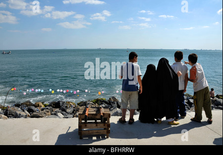 Rücken der fünf Kinder, zwei kleine Mädchen in Schwarz hijabs und drei Jungen in Hosen und T-Shirts im Marmara Meer, Istanbul, Türkei Stockfoto