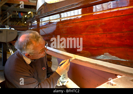 Mann Malerei traditionellen Segelboot auf die Jäger Erbe-Flotte auf den Norfolk Broads Stockfoto