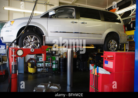 Minivan auf einer Hebebühne im Shop Stockfoto