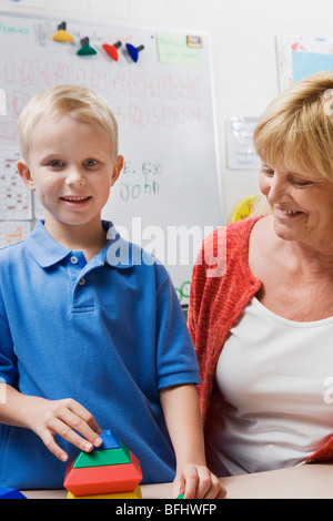 Puzzle-Lehrer beobachten kleiner Junge pädagogische montieren Stockfoto