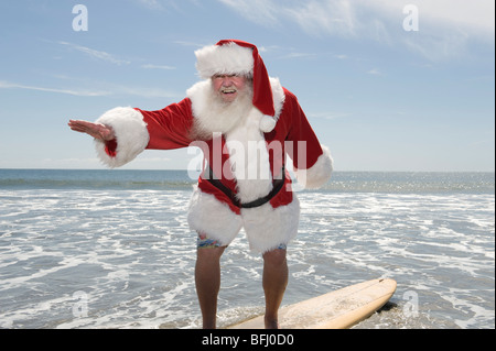 Father Christmas Surfbretter am Rand Wassers Stockfoto