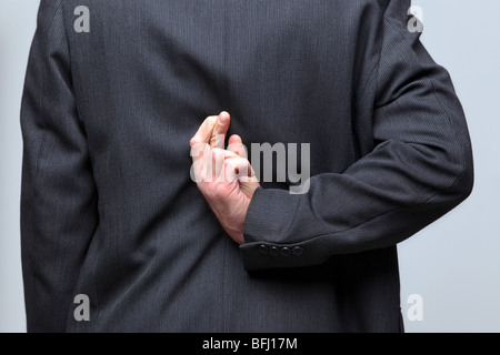 Geschäftsmann mit seinem Daumen hinter seinem Rücken Stockfoto