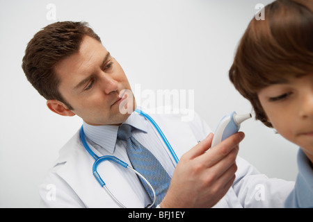 Junge mit Temperatur genommen mit Ohr-thermometer Stockfoto