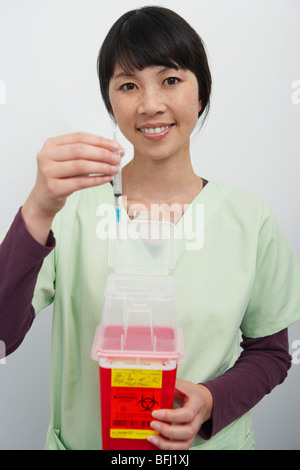 Arzt hält Hyperdermic Nadeln im Krankenhaus, Porträt Stockfoto