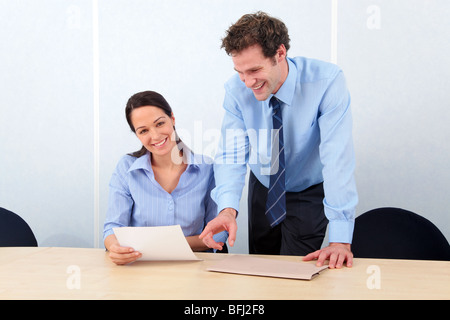 Zwei Geschäftsleute in einem Büro die Frau lächelt in die Kamera. Stockfoto