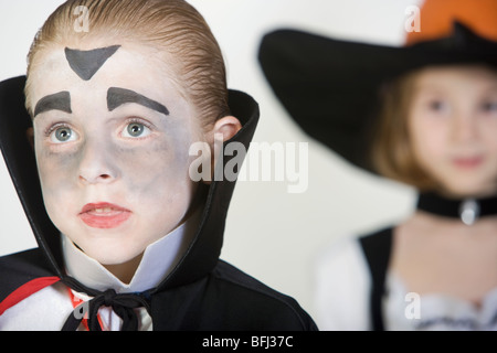 Junge (7-9), Dracula-Kostüm, Mädchen im Hintergrund Stockfoto