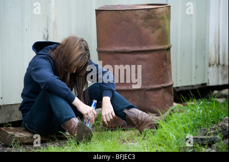 Betrunkene Mädchen trinken ein Alcopop, in einer britischen Straße eingebrochen. Stockfoto