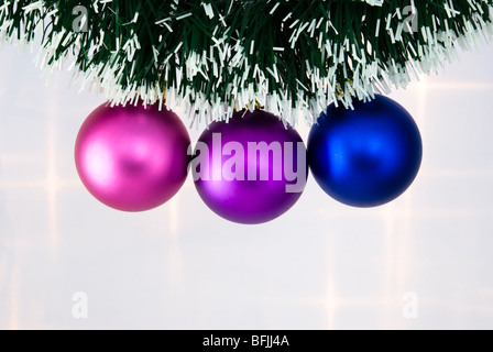 Weihnachtsbaum-Kugeln hängen an einer grünen Kette Stockfoto