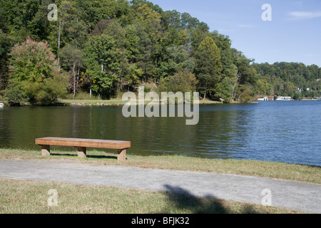 einfache Bank mit Blick auf friedliche Lake Lure North Carolina, NC, USA Stockfoto