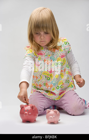 junges Mädchen mit zwei rosa Sparschweine Stockfoto