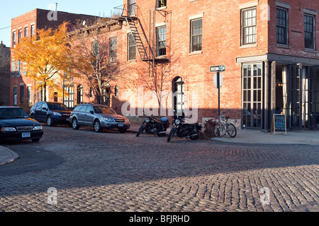 Kopfsteinpflaster Kreuzung & charmant restaurierten roten Backsteingebäuden mit Ecke Bistro in gentrifizierten ruhiger Red Hook NY Stockfoto