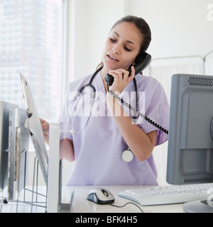Gemischte Rassen Krankenschwester am Telefon im Krankenhaus sprechen Stockfoto