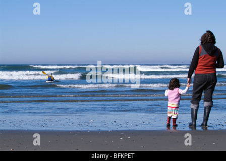 Mutter und Tochter eine Kajak-Surfer beobachten. Stockfoto