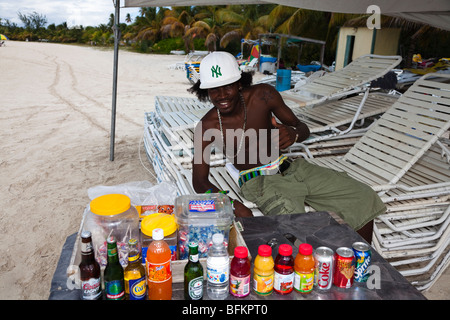 Mann Getränke Verkauf und Vermietung von liegen am Strand bei Lignum Vitae Bay, Antigua Stockfoto