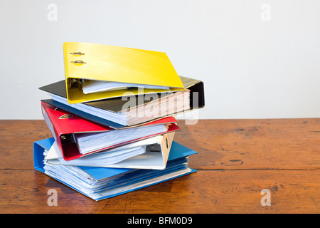 Haufen von farbigen Ringbücher auf Schreibtisch aus Holz Stockfoto