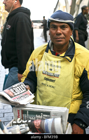 gut gelaunt dunkel-enthäuteten Mann die Zeitung New York Post auf der Plaza in Bowling Green im unteren Manhattan New York City zu verkaufen Stockfoto