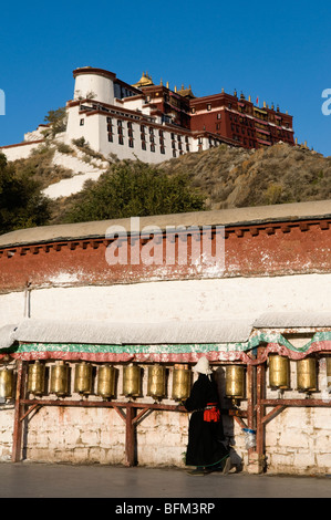 Tibetische Pilger Spaziergänge rund um den Potala-Palast in Lhasa-Tibet Gebetsmühlen drehen. Stockfoto