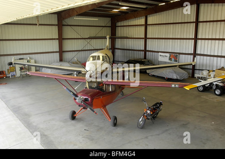 Zwei Flugzeuge im Hangar mit einem Motorrad Stockfoto