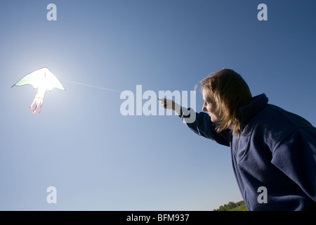 junge Frau, die Drachen auf der grünen Wiese Stockfoto