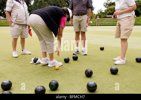 Gruppe von älteren Erwachsenen spielen grüne Bowling im Cambridge Bowlingclub, New Zealand Stockfoto