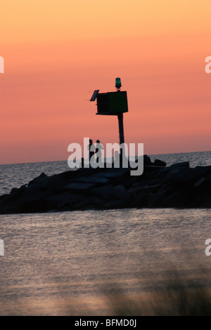 Menschen stehen auf der Mole im Hafen von New Buffalo bei Sonnenuntergang Stockfoto