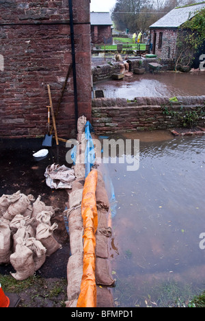 Sandsäcke und Barrieren schützen ein Haus vor steigenden Hochwasser an Eamont Brücke in Cumbria Stockfoto