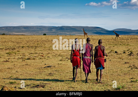 Kenia, Narok District. Maasai-Männer gehen nach Hause über die kurze grasbewachsenen Ebenen in der Nähe von Maasai Mara Wildreservat Stockfoto