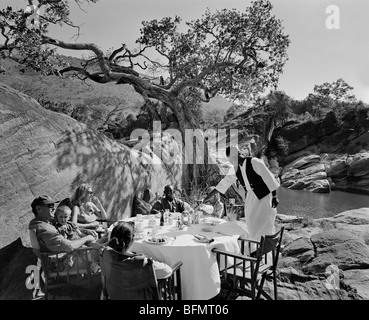 Kenia, Masai Mara National Reserve.  Eine Familie genießen Sie ein stilvolles Frühstück im Busch auf Safari. Stockfoto