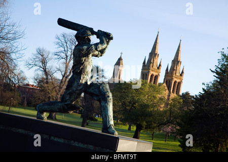Australien, South Australia, Adelaide.Statue des Don (Sir Donald Bradman) mit St.-Peter Kathedrale im Hintergrund. Stockfoto