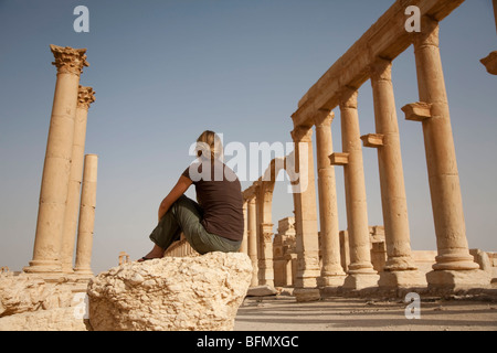 Syrien, Palmyra. Ein Tourist sitzt unter den antiken Ruinen der Stadt der Königin Zenobia in Palmyra. (MR) Stockfoto