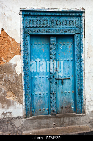 Tansania, Sansibar, Stonetown. Eine bemalte geschnitzte hölzerne Tür eines Hauses in Stone Town. Stockfoto