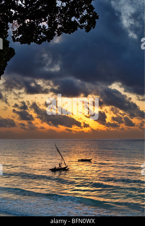 Kenia Mombasa. Ein Ausleger-Kanu setzt die Segel aus Diani Beach bei Sonnenaufgang. Stockfoto