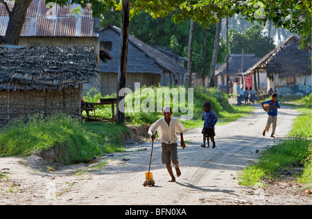 Kenia Mombasa. Ein fröhlicher Junge Junge spielt mit seinen hausgemachten Spielzeug-LKW. Stockfoto