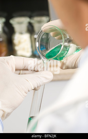 Wissenschaftler, Mischen von Lösungen im Reagenzglas Stockfoto