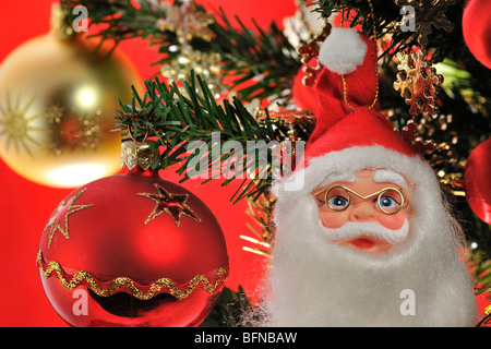 Santa Claus / Weihnachtsmann und Glocken hängen im Baum Stockfoto