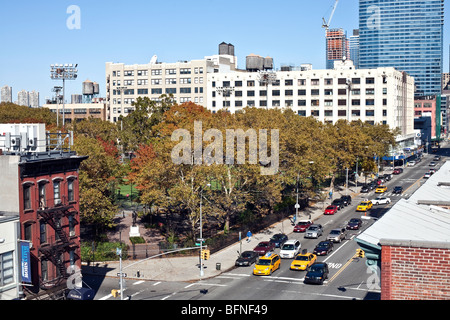 auf der Suche nach Norden hinunter auf 11th Avenue in Richtung DeWitt Clinton Park auf sonnigen Herbstnachmittag mit hellen Laub & alte & neue Gebäude Stockfoto