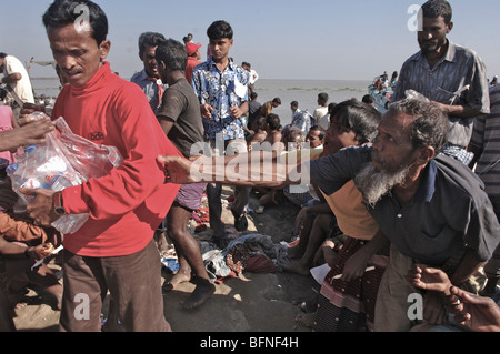 Sturm-Opfer warten auf Hilfsgüter unter militärischer Bewachung nach dem Zyklon Sidr Bangladesch Delta zerstört. Stockfoto