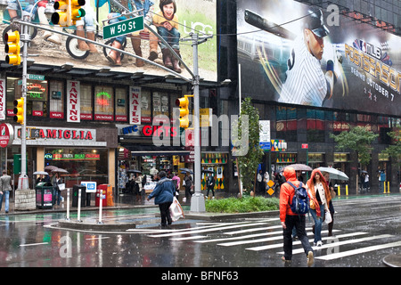 spärlich Fußgänger in bunten regen Getriebe Kreuzung Broadway at West 50th Street am Sonntag der schweren Regenstürme in New York City Stockfoto